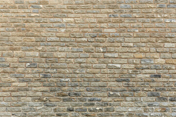 Rugged stone brick wall texture with varied gray and beige tones