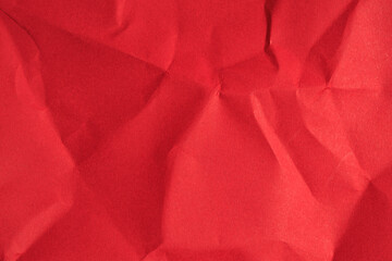 Crumpled red paper texture with folds and wrinkles