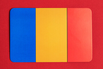 Romanian flag on red background with vertical blue, yellow, and red stripes