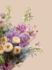 Close-up of a pastel floral arrangement featuring pink roses, lavender blooms, and soft yellow wildflowers