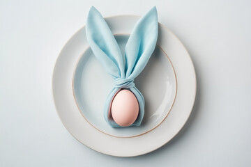 Creative easter table setting with blue napkin folding into bunny ears on egg