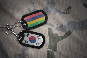 vintage army blank, dog tag with flag of mauritius and south korea on the khaki texture background....