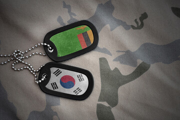 vintage army blank, dog tag with flag of zambia and south korea on the khaki texture background....