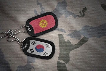 vintage army blank, dog tag with flag of kyrgyzstan and south korea on the khaki texture...