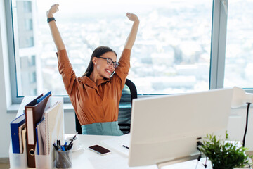 Contented happy businesswoman sitting at workplace, stretching arms and relaxing, taking break....