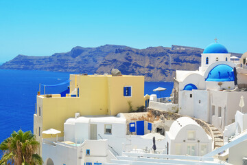 Oia village on Santorini island, Greece. Traditional and famous houses and churches with blue dome...