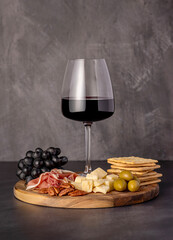 Food photography of red wine, cheese parmesan, prosciutto, olives, pecan, grapes, crackers, appetizer, wine glass, assortment, party meal