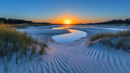 Fototapeta premium Sunset at a sandy beach with water.