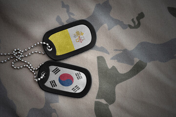 vintage army blank, dog tag with flag of vatican city and south korea on the khaki texture...