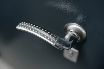 modern metal doorknob in door to apartment, coming home concept