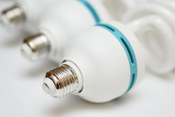 white eco-friendly energy-saving light bulb, metal base close-up, isolated on white background