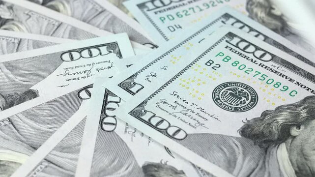 American money turnover, batch of one hundred dollar bills, concept of financial success, lottery or big win. Another US dollar added to the pot