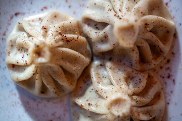 Khinkali dumplings dusted with spices on a plate shot in closeup detail showing texture