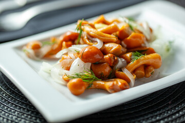 Close-up of marinated mushrooms garnished with fresh dill and onions on a white plate