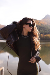 beautiful slavic woman with dark hair in elegant outfit posing among beautiful nature
