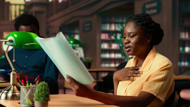 African american stressed scholar failing to comprehend and memorize lesson notes, struggling to learn the theory for her exam. Frustrated concerned university student at the library. Camera B.