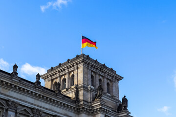 Obraz premium German flag waving on Reichstag building in Berlin