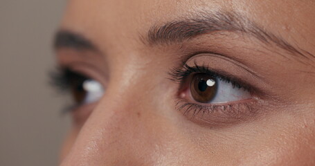 Fototapeta premium Quick video of a girl looking to the side, blinking with her beautiful dark brown eyes.