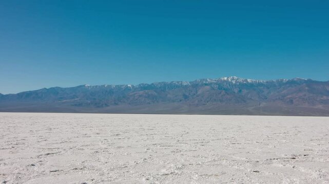 Enjoy a smooth steadicam shot of the stunning salt crust formations in Badwater Basin, capturing the unique beauty of Death Valley National Park, California in 4K.