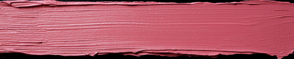 Fototapeta premium Soft pink paint swatch spread smoothly on a black background showcasing texture and color depth