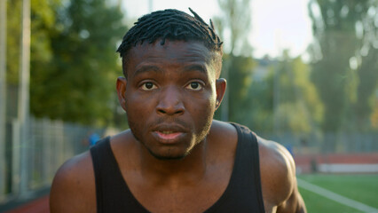 African American ethnic man guy runner jogger sprinter running on race track outdoor stadium sport...