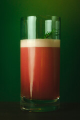 Foamy Red Cocktail with Herb Garnish Elegant Drink Against a Rich Green Backdrop, Perfect for Summer