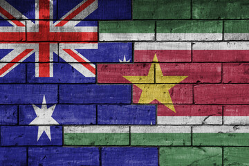 colourful painted big flag of australia and flag of suriname on a massive old brick wall...