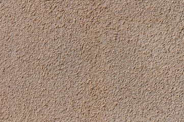 Textured surface displaying sandy hues and subtle patterns against a neutral backdrop at midday light