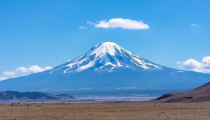 Snow capped mountain under blue sky with cloud and desert terrain