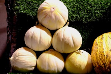 Obraz premium Close-up of melons and watermelons sold by a street vendor at night. Vegetable and fruit prices. Summer fruits Healthy vegetarian diet. Organic farming.
