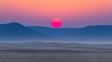 Fototapeta premium Vibrant sunset over misty desert dunes and mountains.