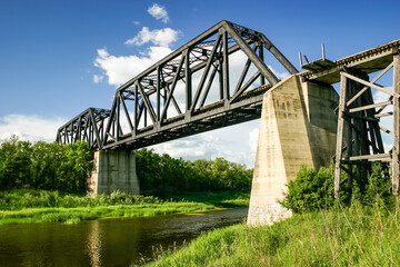 A bridge spans a river with a green grassy bank on either side