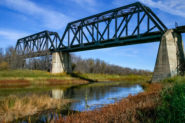 A bridge spans a river with a green and brown landscape