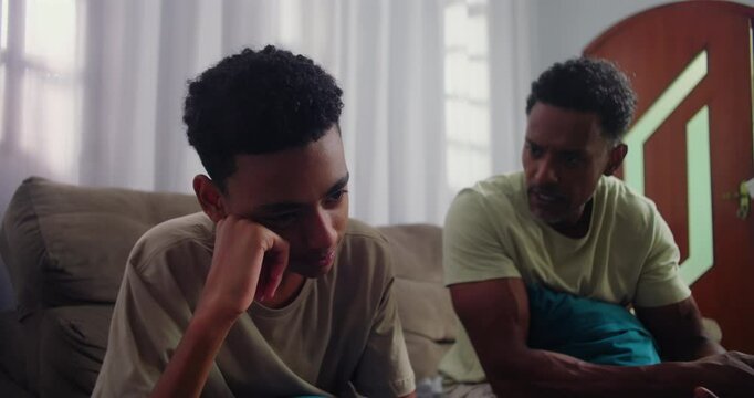 Father scolding his teenage son, expressing frustration and discipline, while the son ignores with a bored expression, showcasing conflict and generational disconnect
