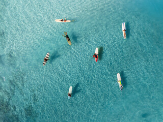 Drone Aerial View of Surfers Riding Waves in Hawaii Sea with Surfboards in the Blue transparent Ocean 