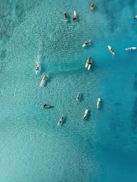 Drone Aerial View of Surfers Riding Waves in Hawaii Sea with Surfboards in the Blue transparent Ocean 