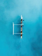 Drone Aerial View of a Canoe Gliding Through Waves in Hawaii's Transparent Blue Ocean
