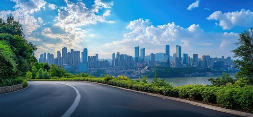 Obraz premium Scenic highway curve overlooking city skyline, river, and lush greenery. Use Travel, real estate