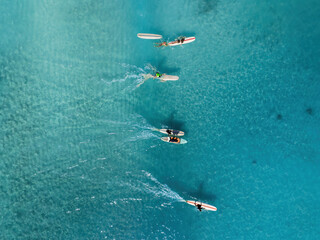Drone Aerial View of Surfers Riding Waves in Hawaii Sea with Surfboards in the Blue transparent Ocean 
