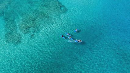 Drone Aerial View of Surfers Riding Waves in Hawaii Sea with Surfboards in the Blue transparent Ocean 