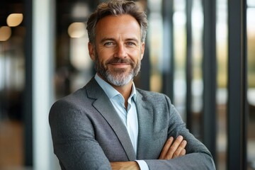 confident executive businessman standing in modern office smiling mid aged professional manager looking at camera leadership portrait
