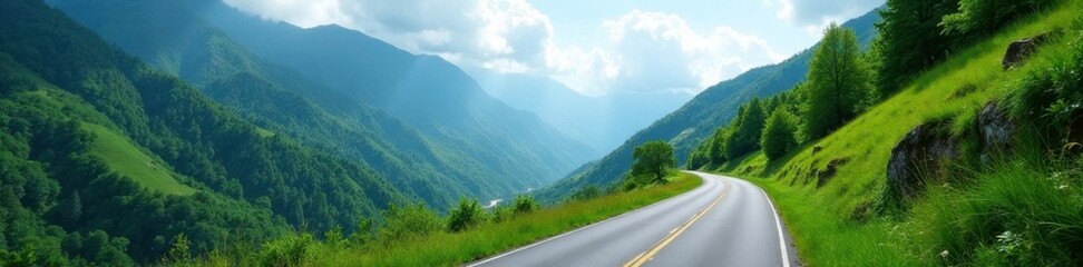 Fototapeta premium Narrow winding road through lush green mountains, trees, clouds, landscape