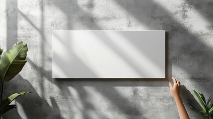 Empty white horizontal rectangle poster mockup with a soft shadow on a neutral light grey concrete wall background. This flat lay, top view design offers a minimalist and modern aesthetic.