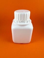 White medicine plastic bottle isolated on orange background