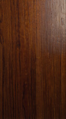 A polished wood surface with smooth, rich mahogany tones and a reflective sheen, highlighting the natural beauty of the grain.