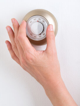 Adjusting a round dial thermostat for indoor temperature control