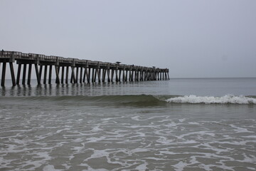 Fototapeta premium Ocean front with a sandbar and a fishing pier at Jacksonville Beach, Florida. 