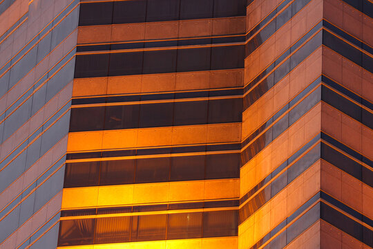 Abstract futuristic architectural background. Office building windows in black and orange tones.