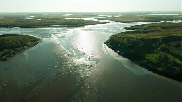 Serene Aerial View of a Meandering River Surrounded by Lush Greenery and Reflective Waters Under a Bright Sky