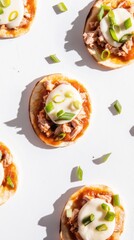 Tuna topped flatbreads with tomato sauce and green onions in playful arrangement